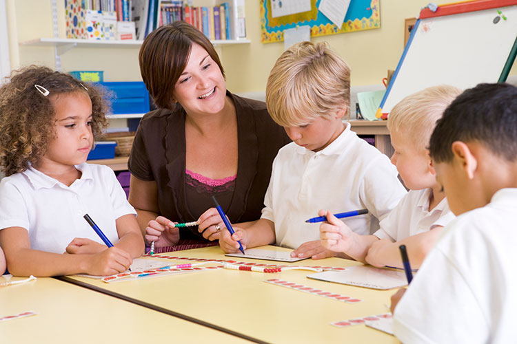 teacher supporting young students