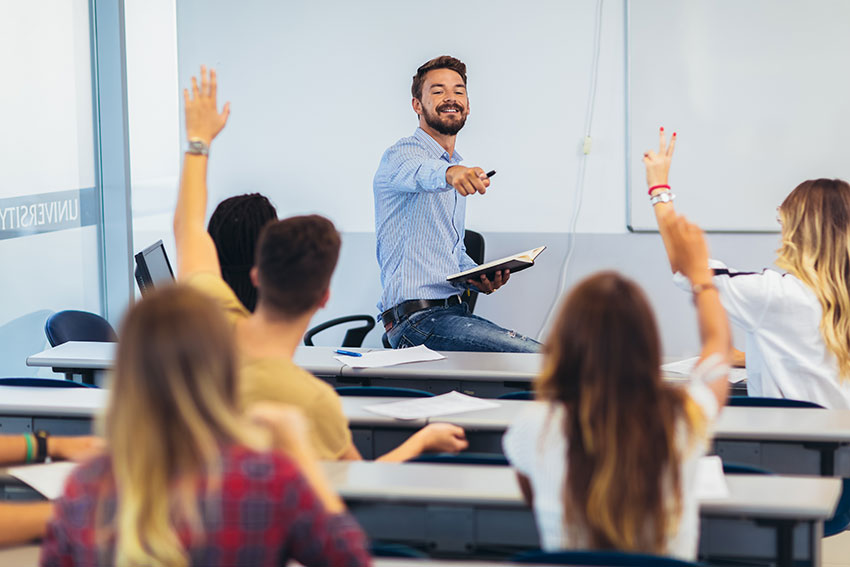 male teacher surveys questions class