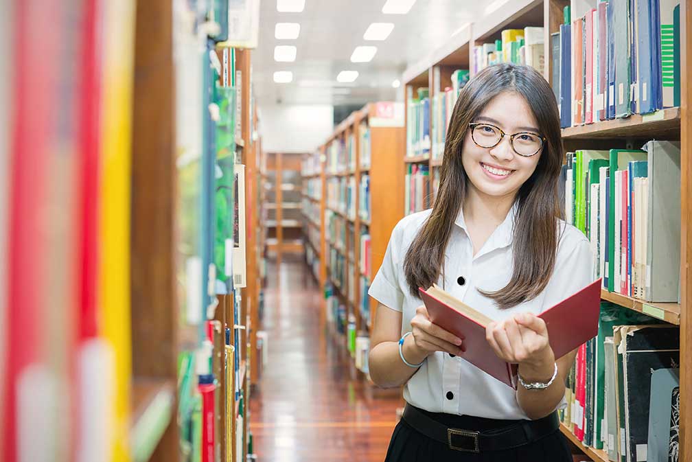 student in library with book